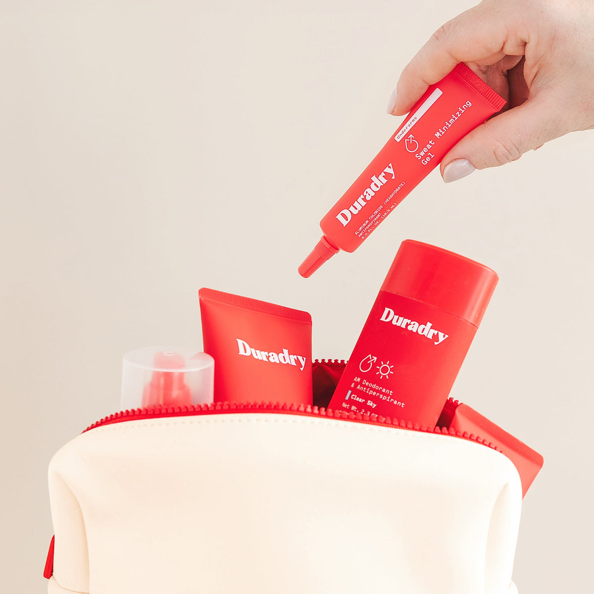 Cream travel bag with red Duradry tubes on top near the zippered opening.