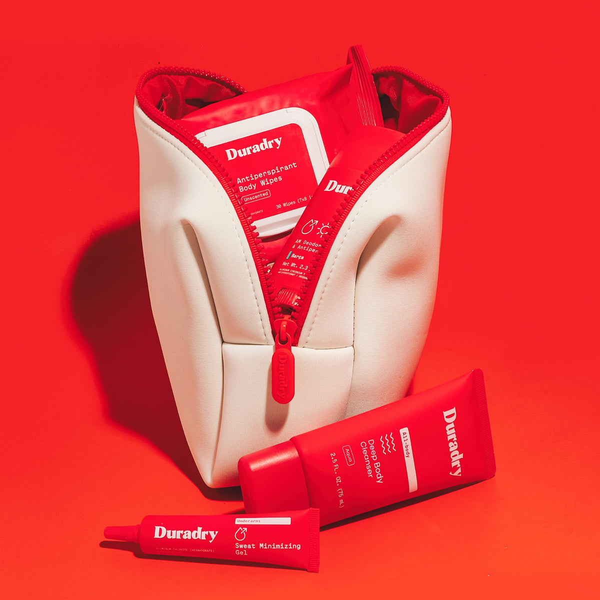 Cream travel bag open with red Duradry packets and tubes inside pouch.