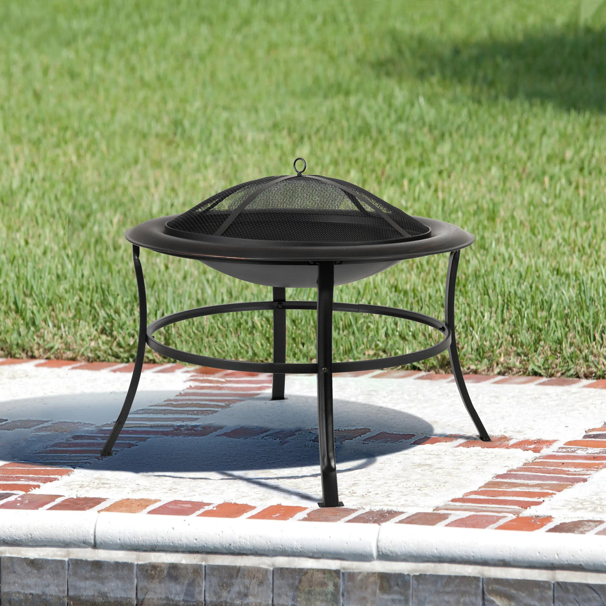 Round metal fire pit with black legs and mesh spark screen on top