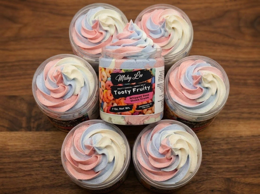 Multiple whipped soap tubs with pastel swirl tops on wooden surface