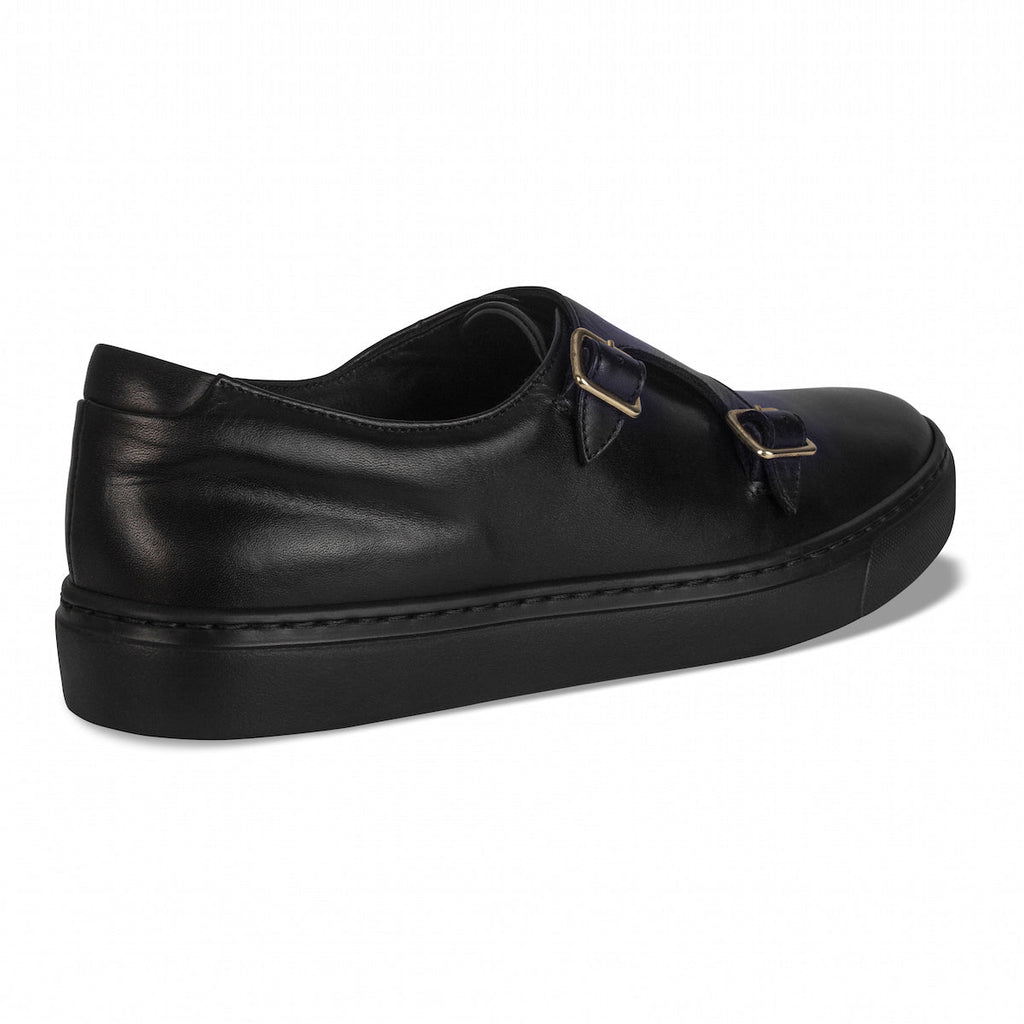Black slip-on loafers with two gold-tone buckles and stitched trim