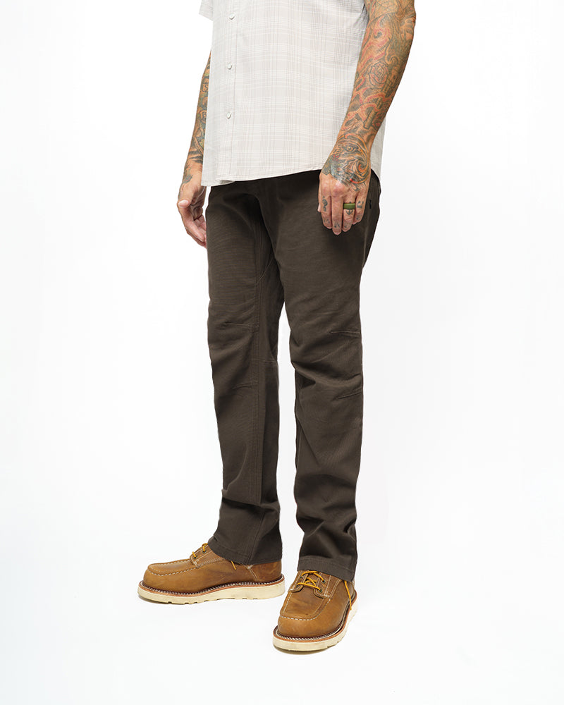 Dark brown taper-fit pants standing view, tapered legs with front hand pockets.