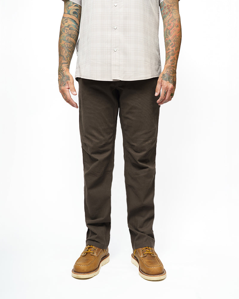 Dark brown taper-fit pants on model, full-length front view with tapered silhouette.