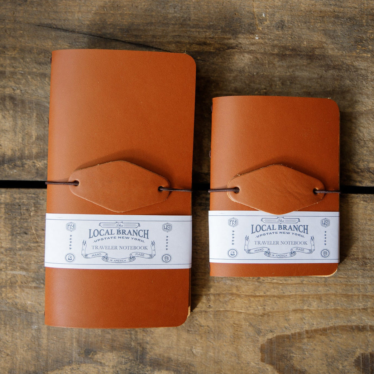 Two leather traveler notebooks with strap closure and Local Branch labels, flat lay