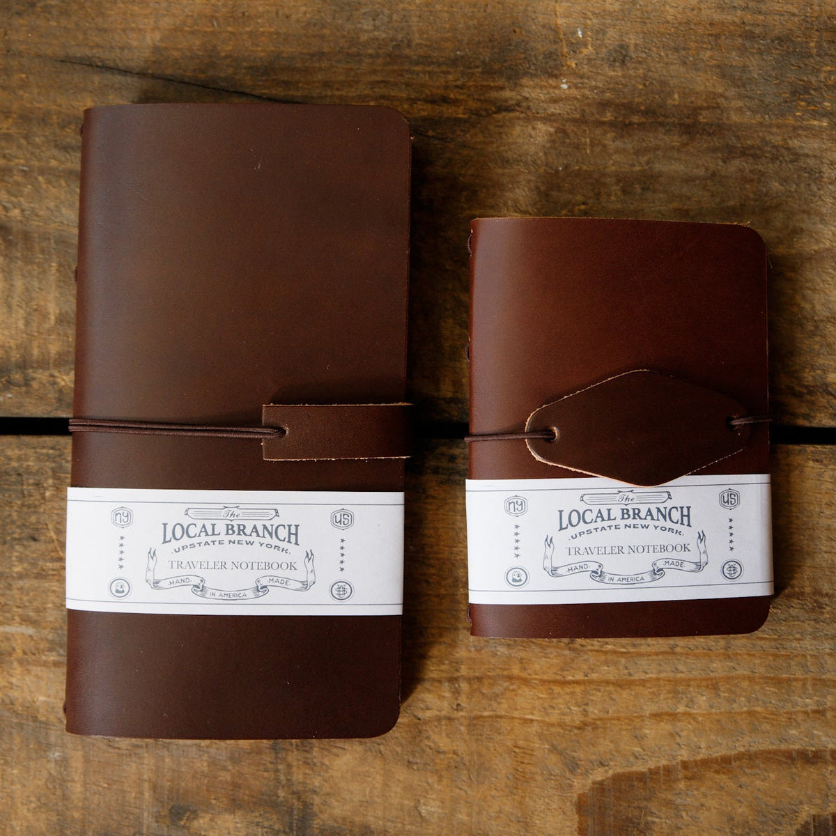 Two leather traveler notebooks with strap closure and Local Branch labels, side view