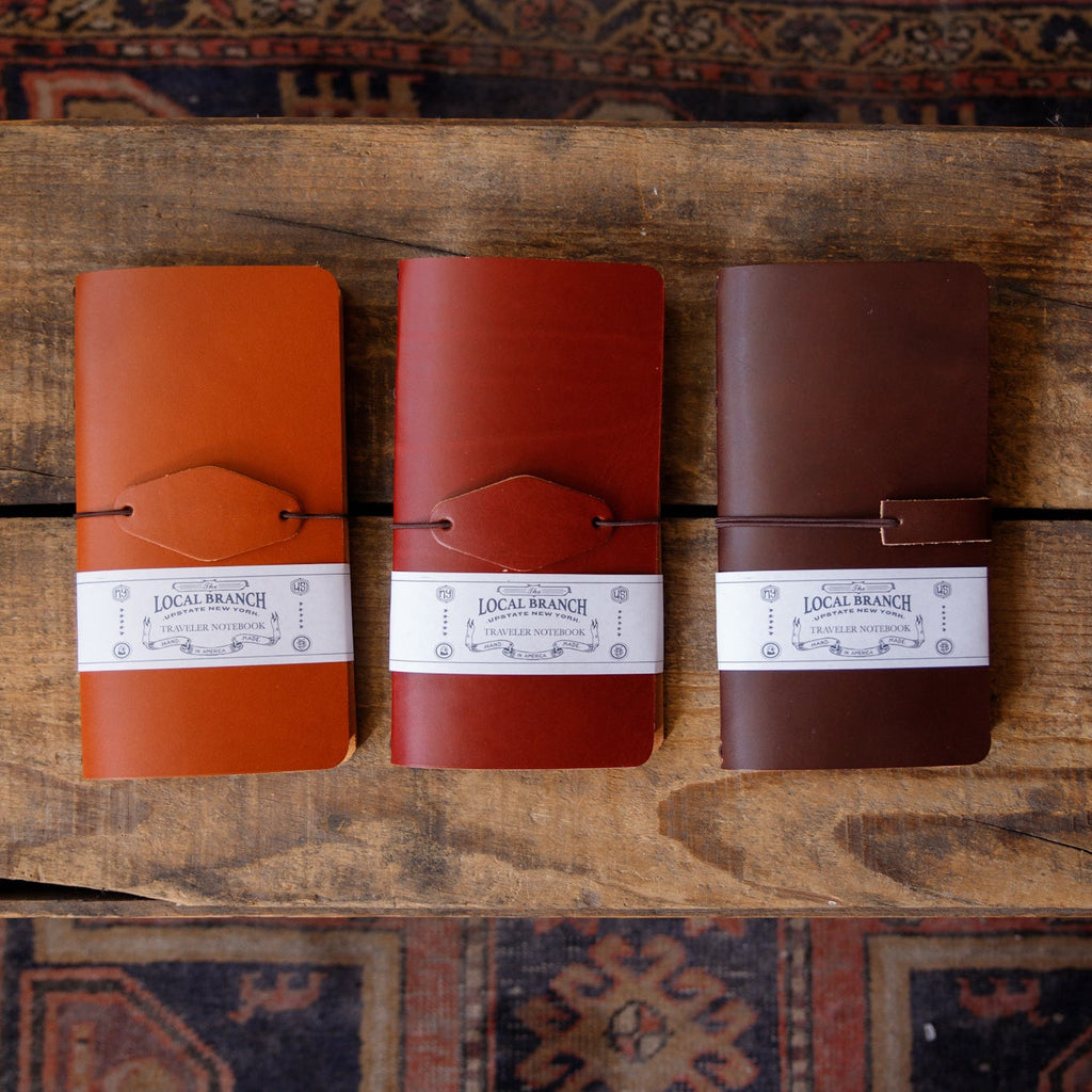 Set of leather traveler notebooks with tie strap closure, three colors shown