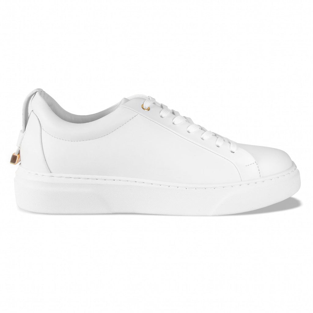 White low-top sneakers with white laces, gold lace tips, and thick platform sole