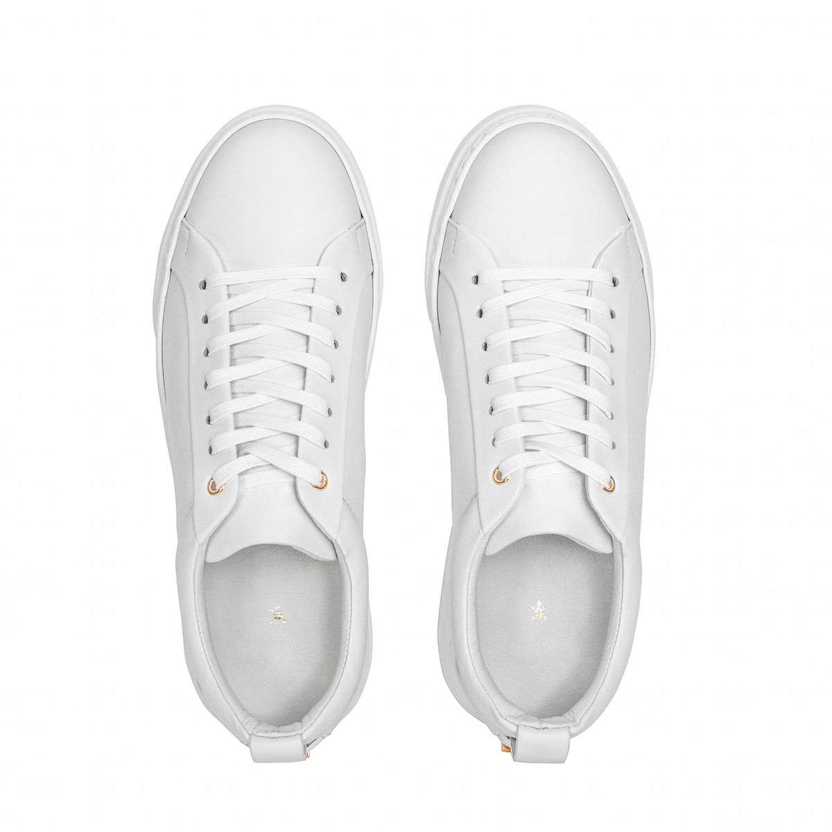 White lace-up sneakers front view with gold lace tips and cushioned interior
