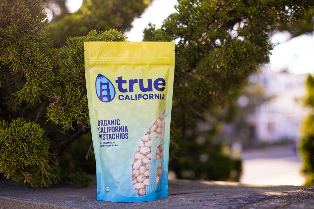 true California organic California pistachios bag standing outdoors, lightly sea-salted