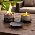 Outdoor candle holder trivet, dark gray base with ball feet, holds a lit candle