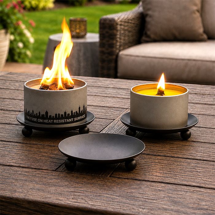 Outdoor candle holder trivet, dark gray base with ball feet, holds a lit candle