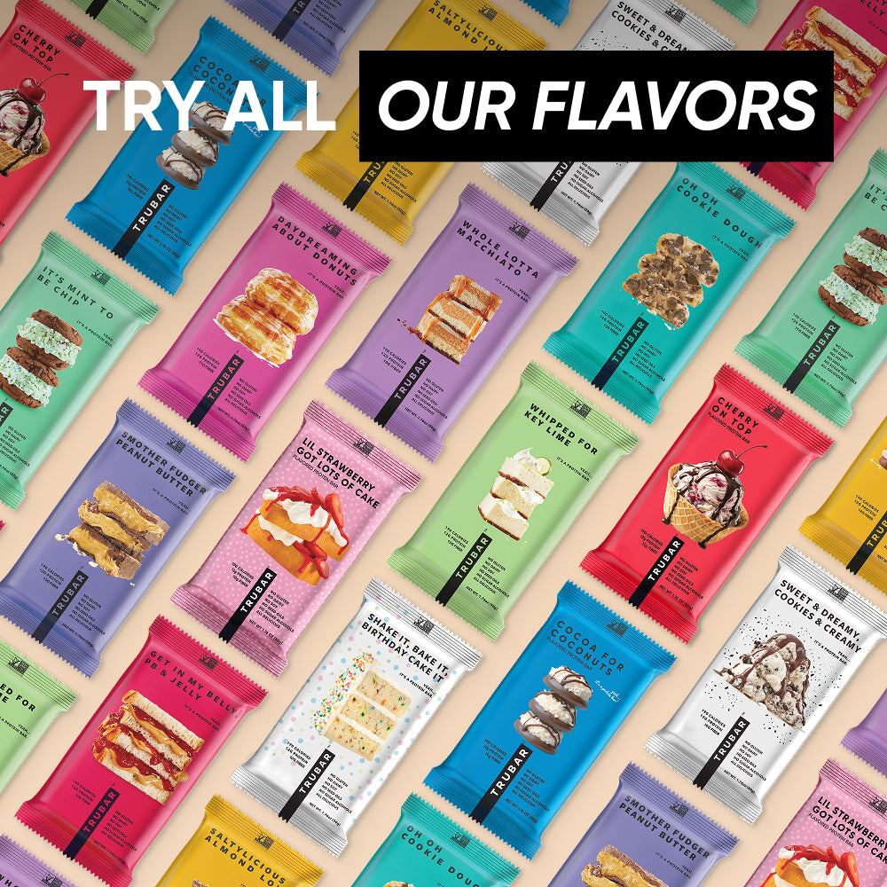 Assorted TRUBAR protein bar packages in colorful wrappers arranged in rows