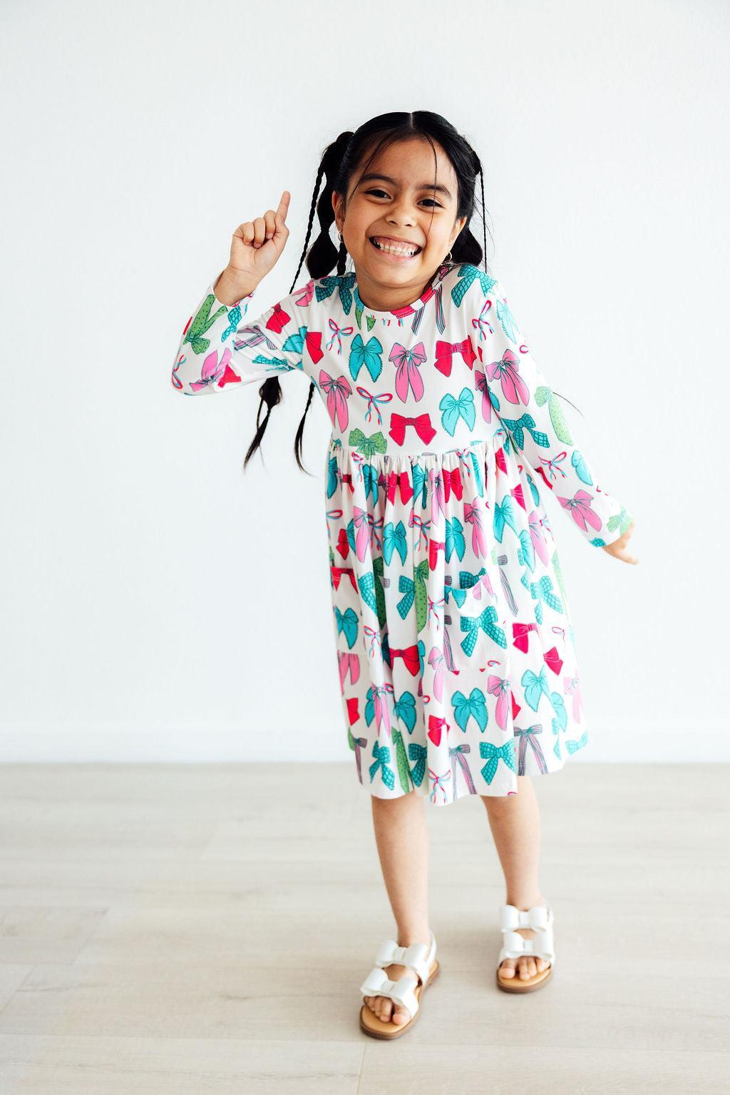 Girls long-sleeve twirl dress with colorful bow print, tiered skirt and ruffle hem