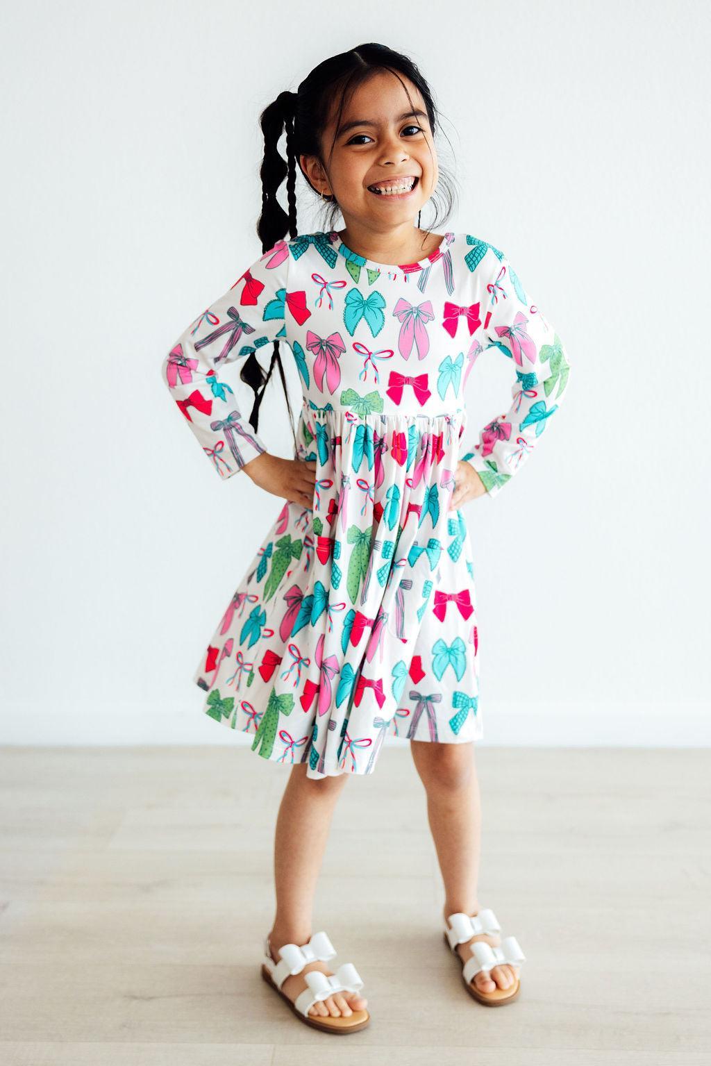 Girls long-sleeve twirl dress with colorful bow print, gathered waist and flared skirt