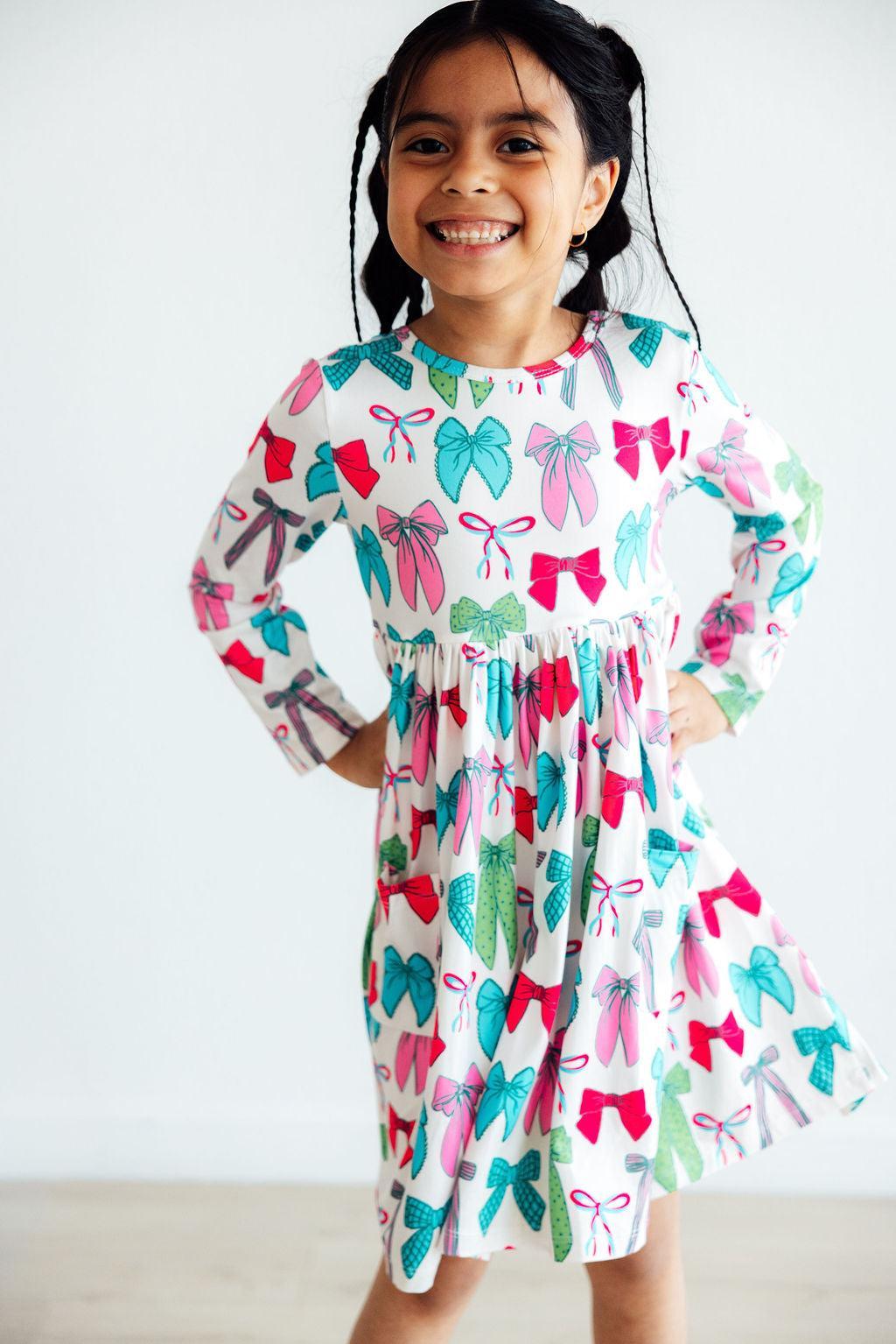 Girls long-sleeve twirl dress with colorful bow print, full skirt and elastic neckline