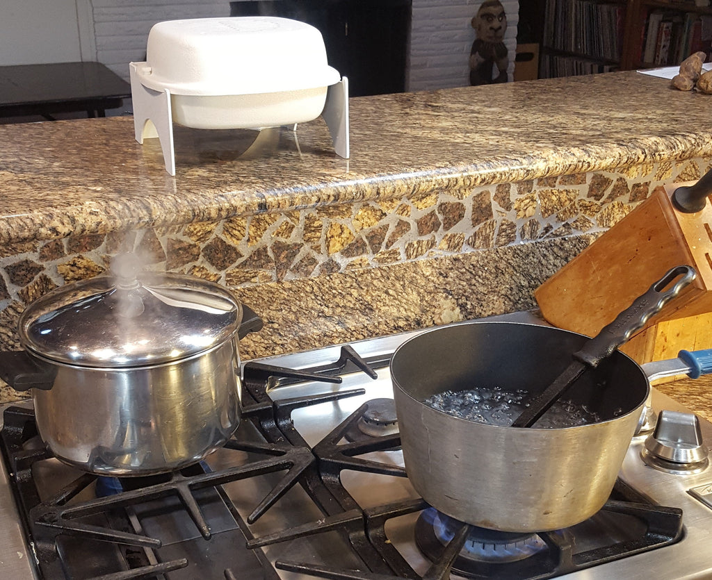 White air purifier dome on bracket over a counter beside a gas stove
