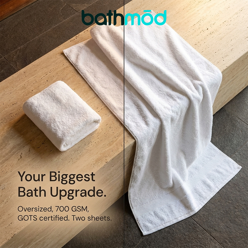 Two white bath sheets neatly folded on a tile floor