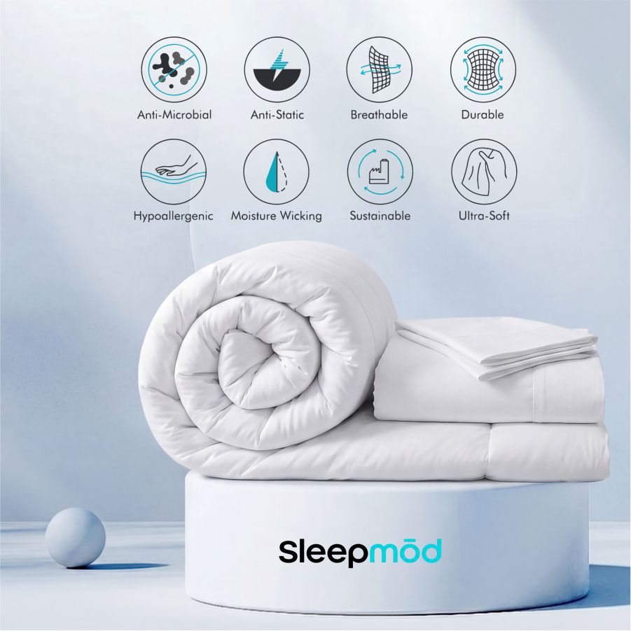 Rolled white comforter with stacked pillow shams
