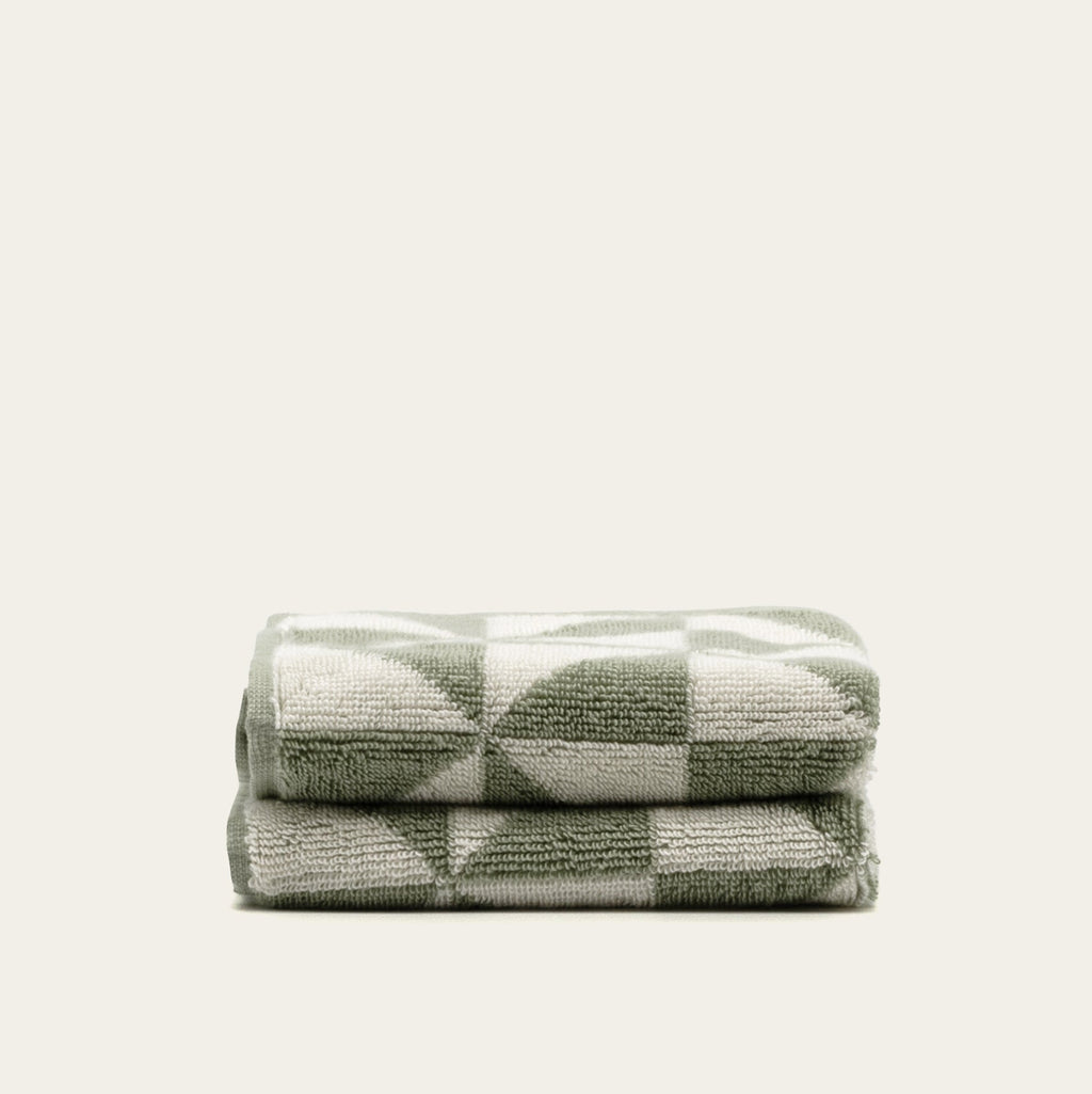 Sage and ecru check-pattern cotton towels, folded into a compact two-stack set.