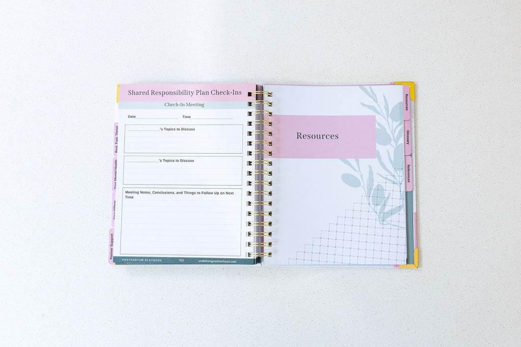 Postpartum planner book open to planning pages with tabs and section headers