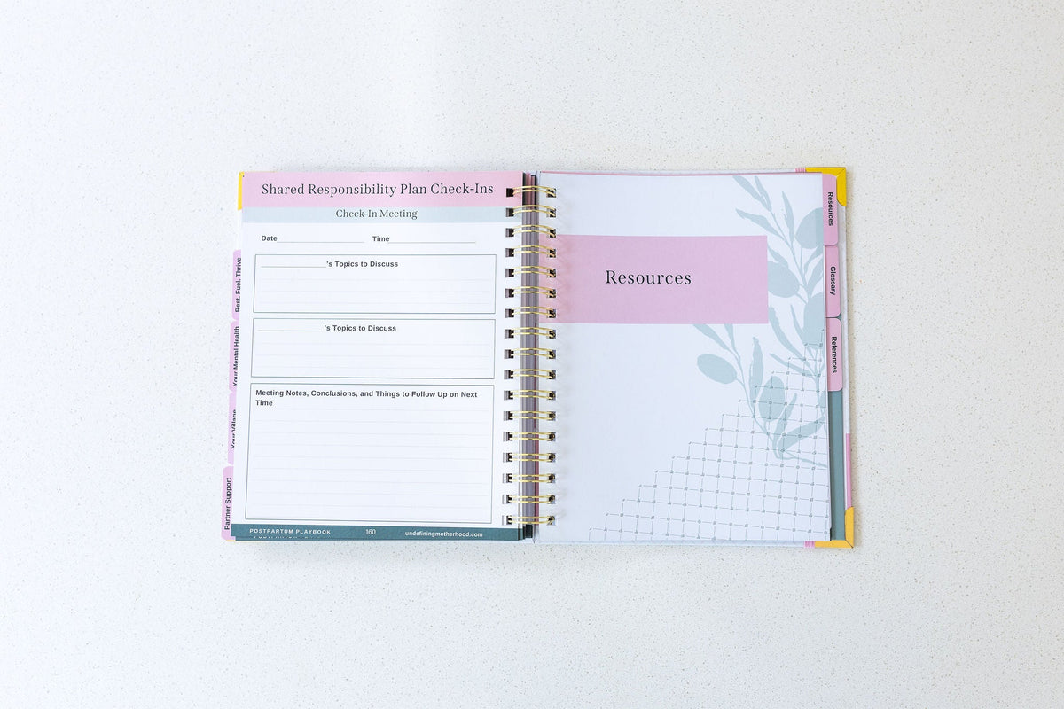 Postpartum planner book open to planning pages with tabs and section headers