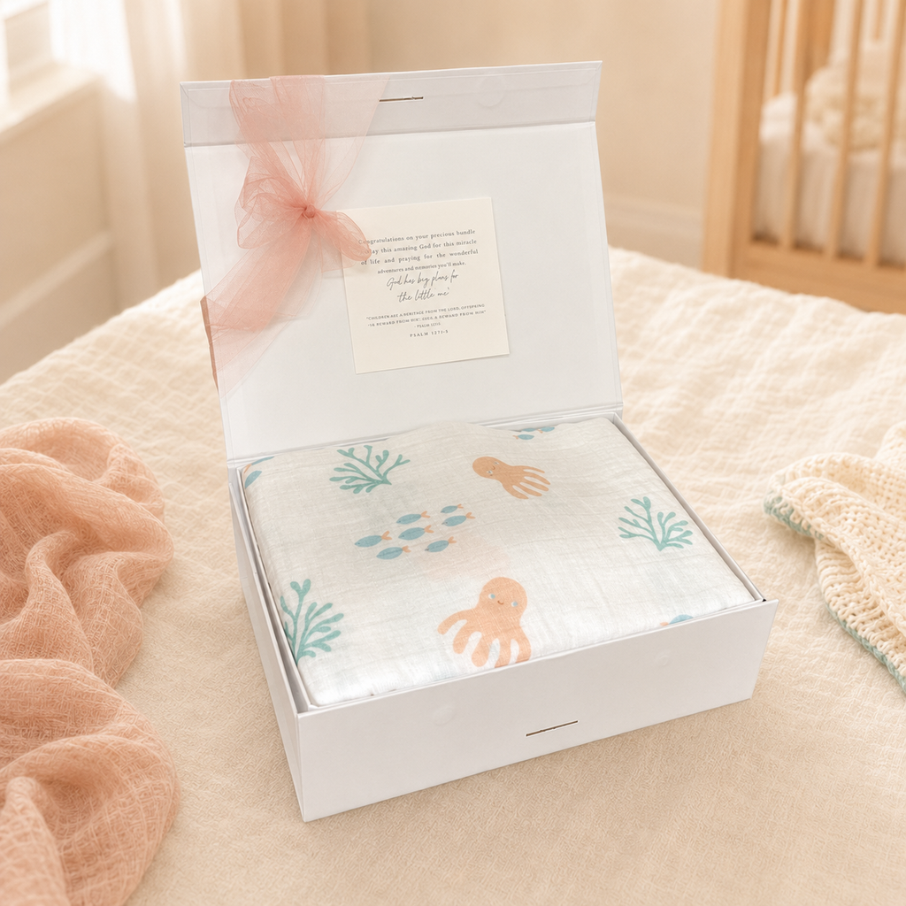 Under-the-sea muslin swaddle blanket with sea-creature print, folded in gift box