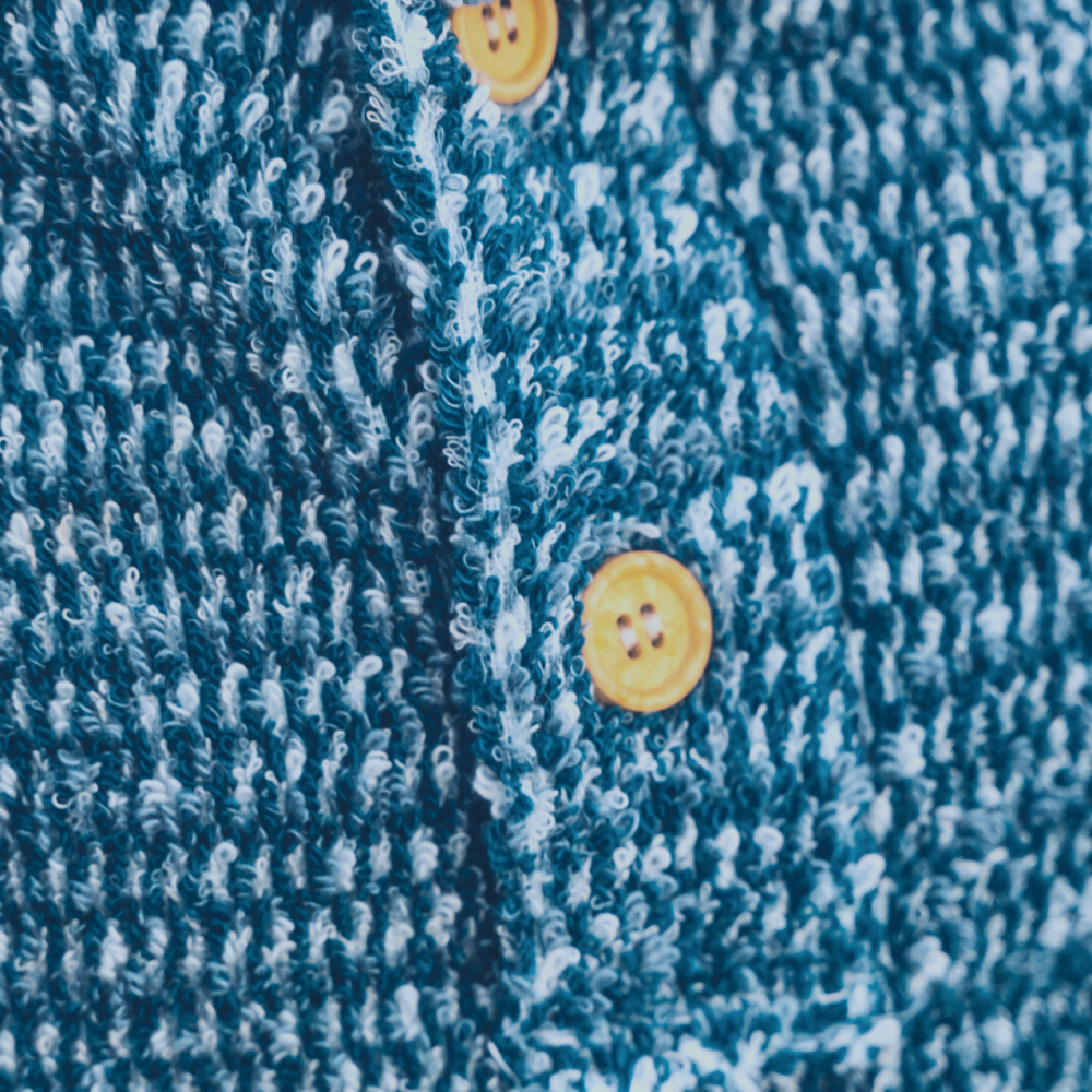Indigo blue textured knit blanket hoodie with yellow button details and hood
