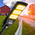 Black solar street LED light with three LED modules and attached solar panel, angled view