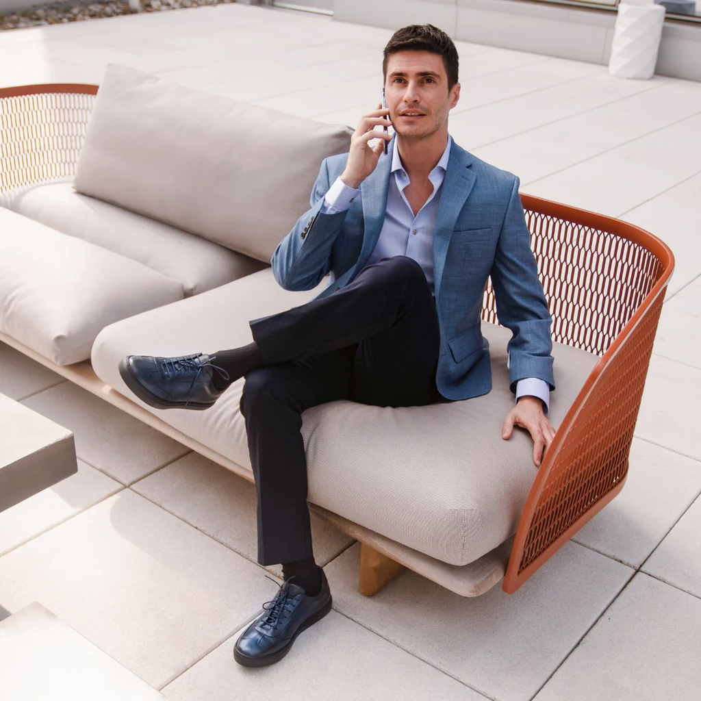 Men's dark blue leather lace-up sneakers shown with dress attire