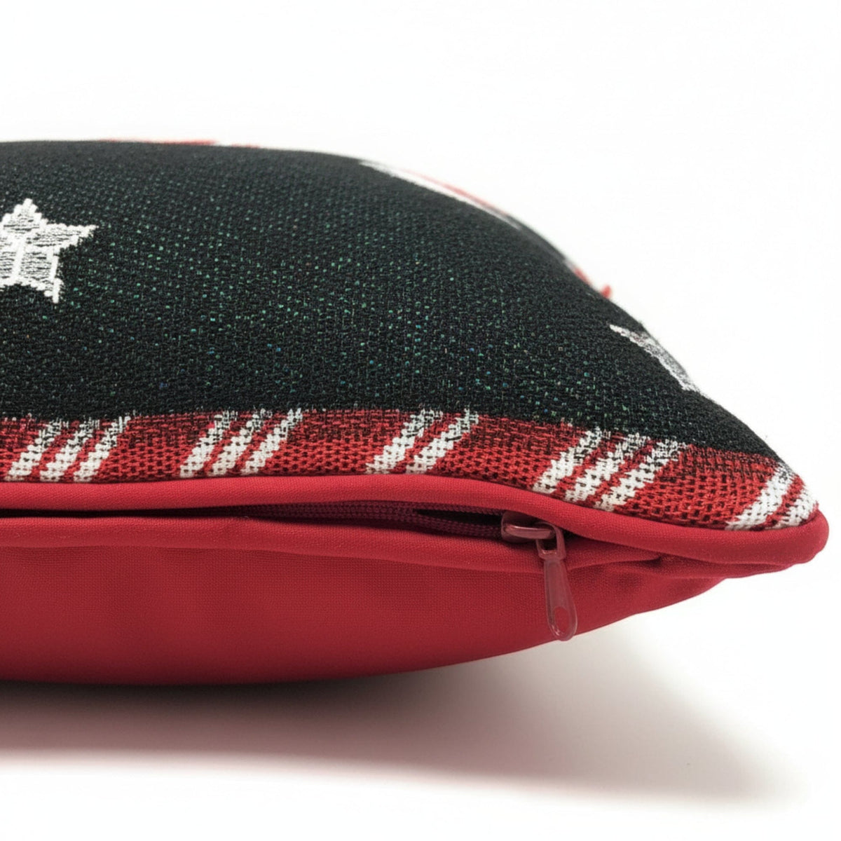Black pillow cover close-up with red zipper edge and red/white peppermint pattern