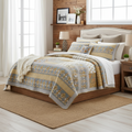 Cotton quilt bedspread set with blue and gold floral border design, layered over a bed