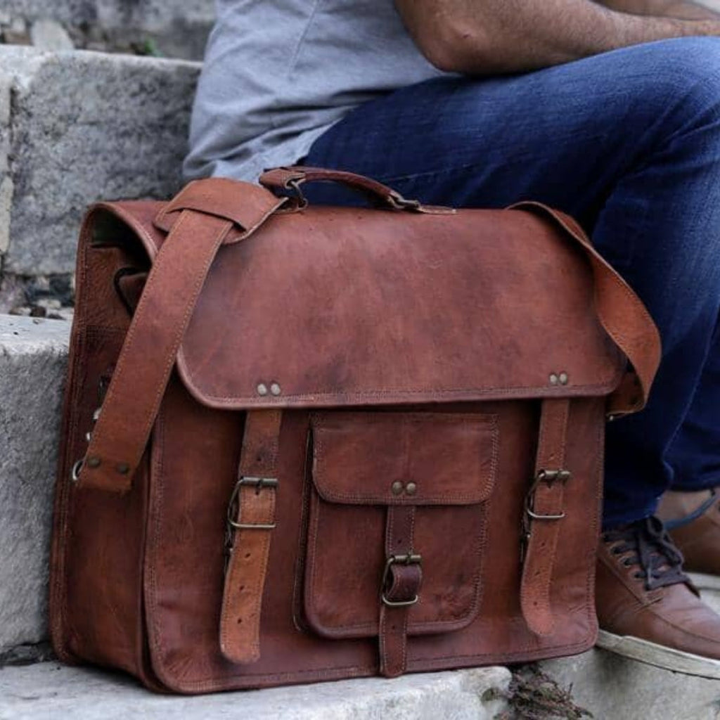 Brown leather messenger-style briefcase with shoulder strap and front flap pocket