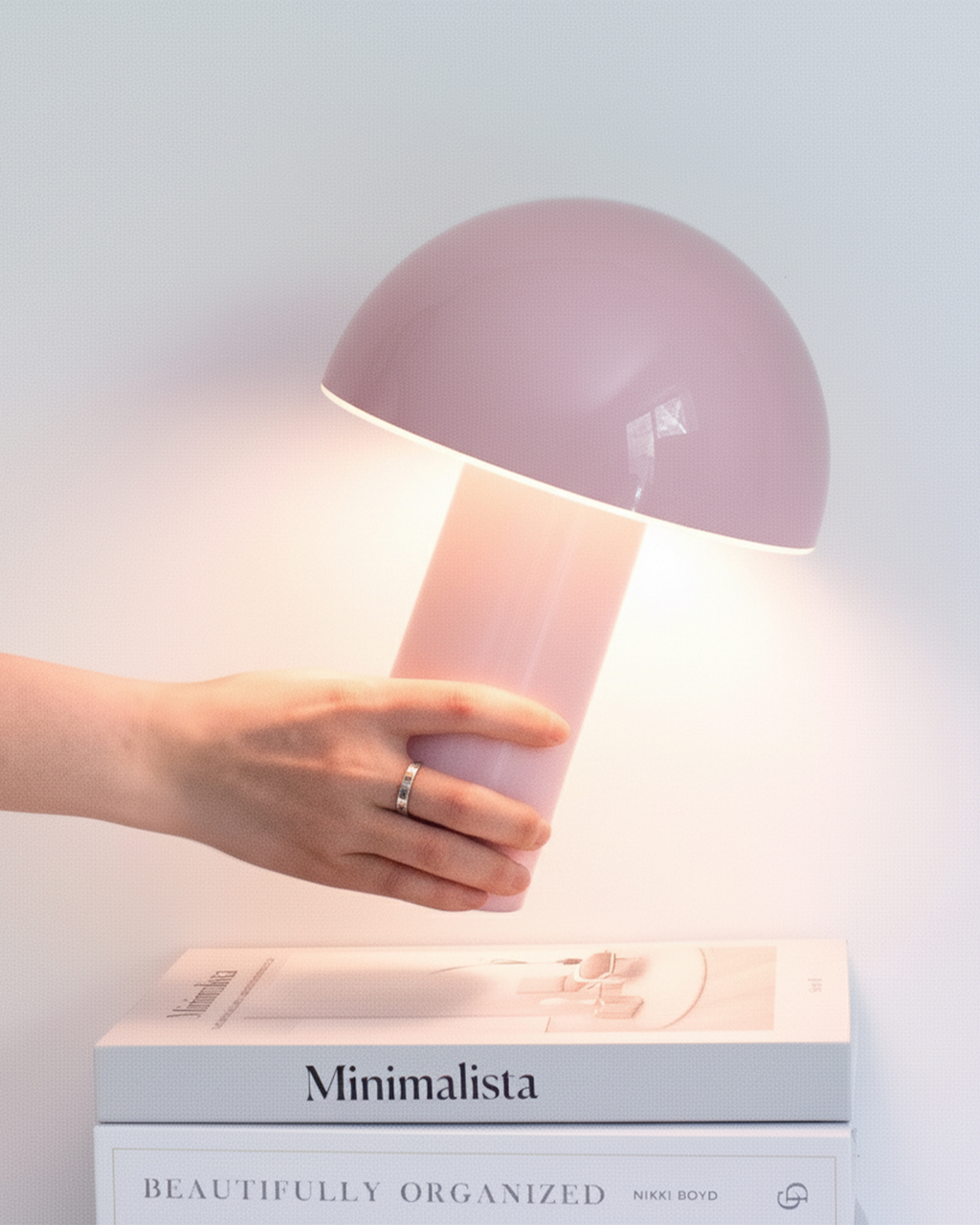 Pink portable lamp with domed shade and cylindrical base, lit