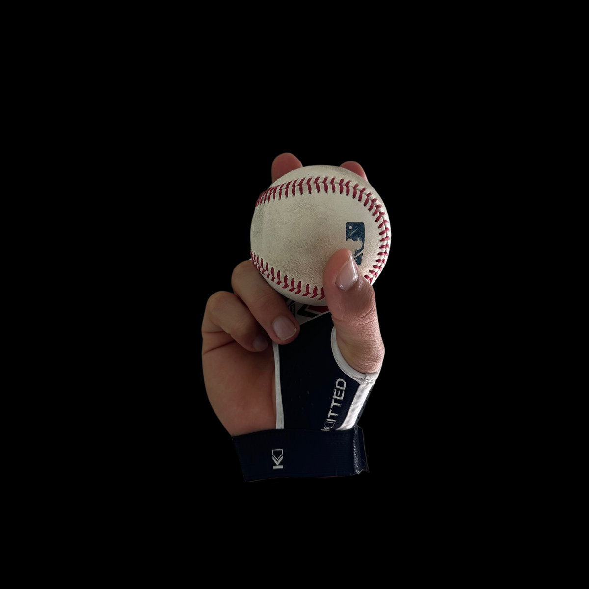 Baseball spin-grip training glove holding a baseball with visible seam details
