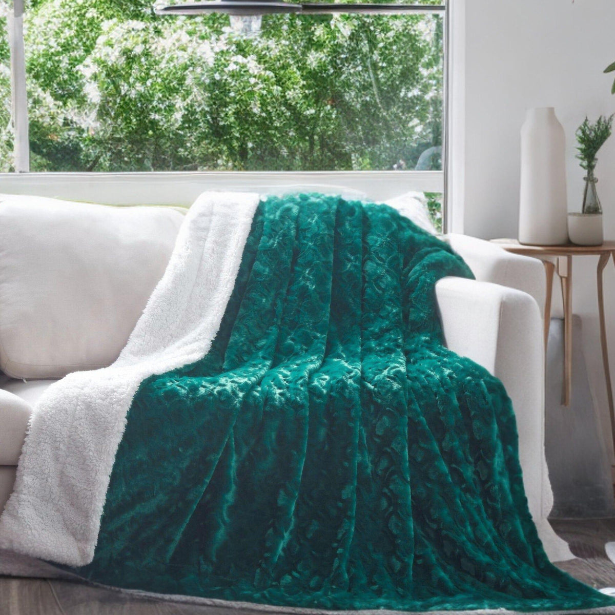 Emerald green faux fur sherpa throw blanket draped over a couch