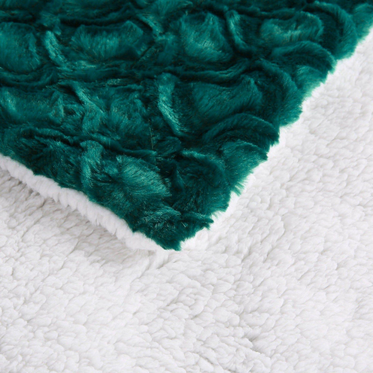 Emerald green faux fur edge with white sherpa backing on a throw blanket