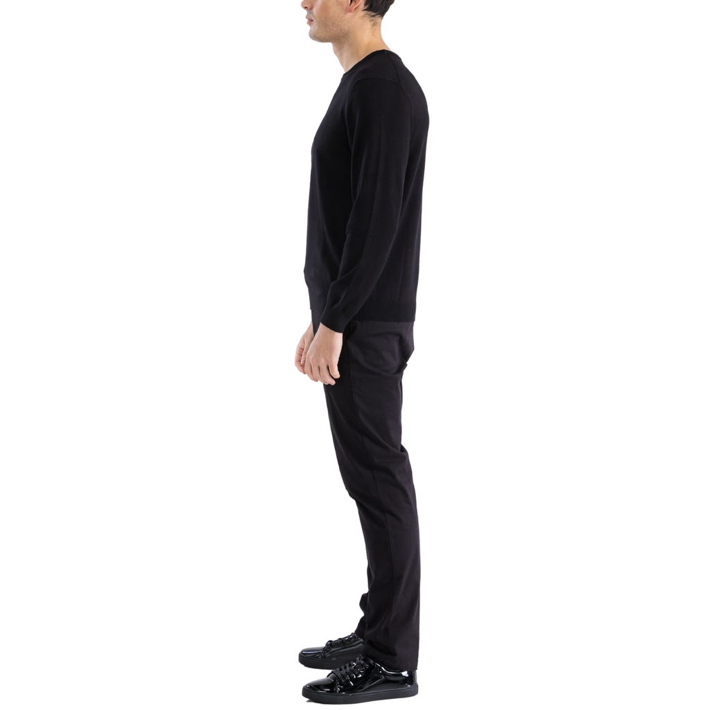 Men's black crewneck knitted pullover sweater with ribbed cuffs, side view