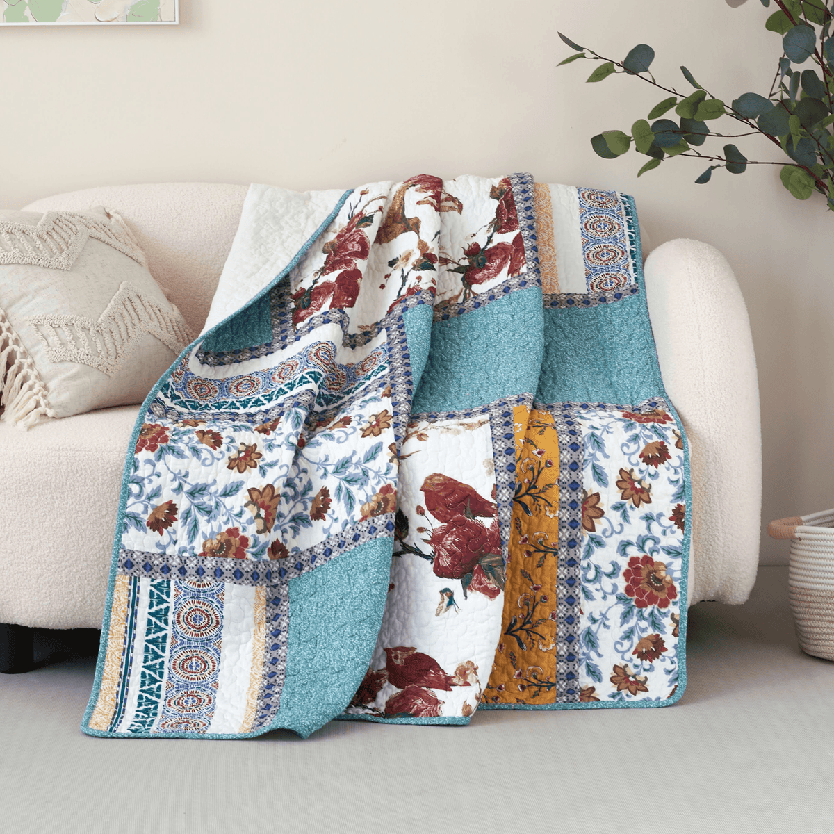 Quilted patchwork throw blanket with blue, white, red, and yellow blocks and floral bird prints