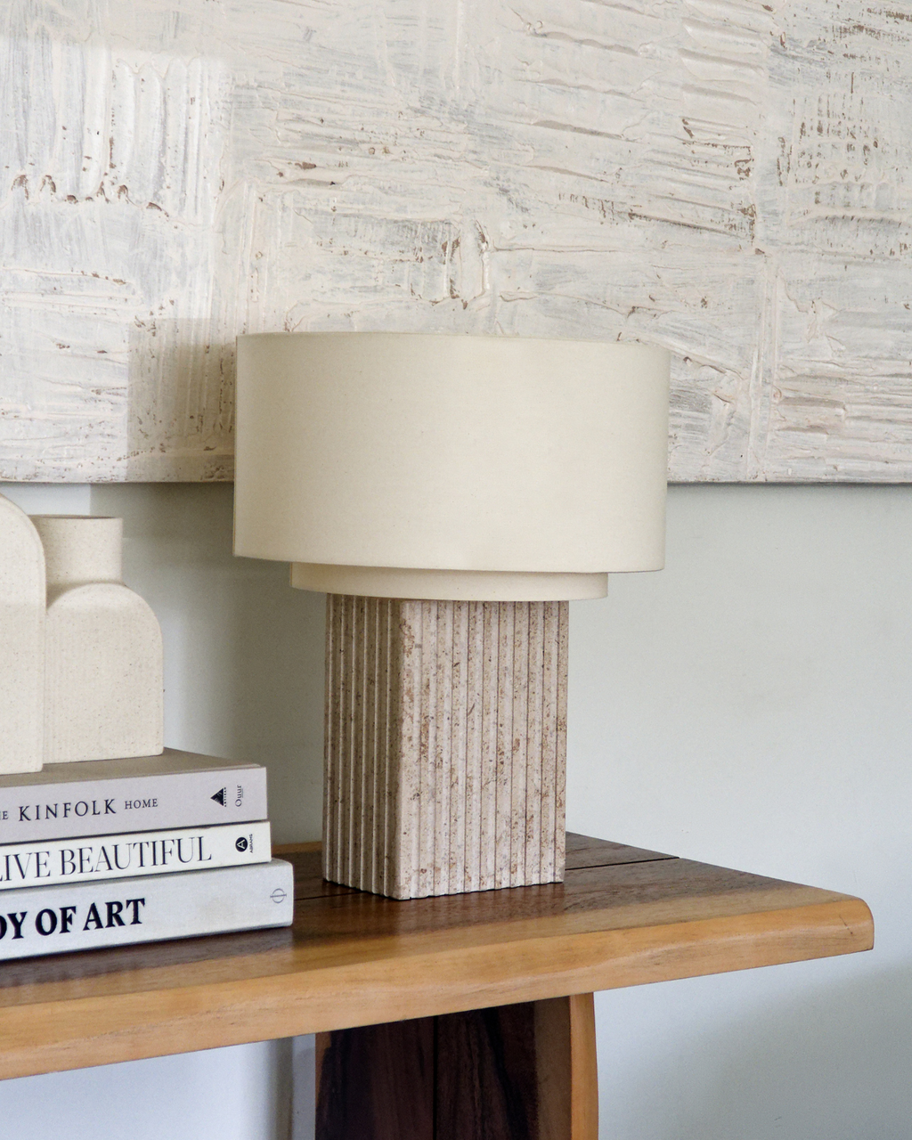 Table lamp with off-white drum shade and ribbed tan ceramic base
