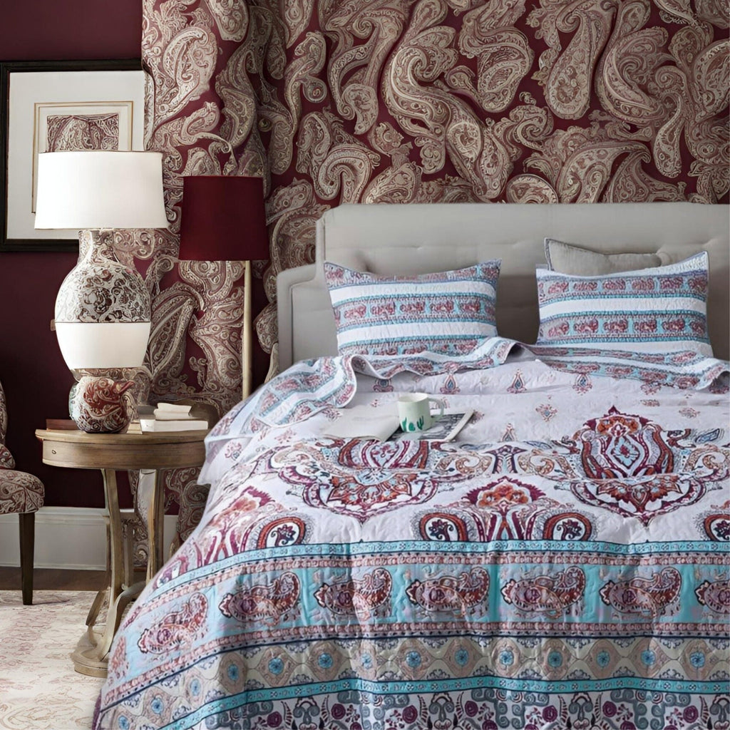 Paisley quilt set in white with blue and burgundy ornate motifs, with pillow shams