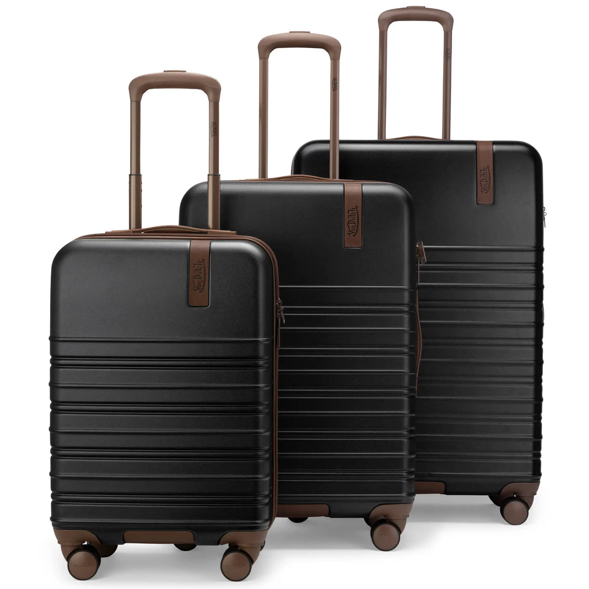 3-piece hardside spinner luggage set, dark shells with tan handles and stacked profiles