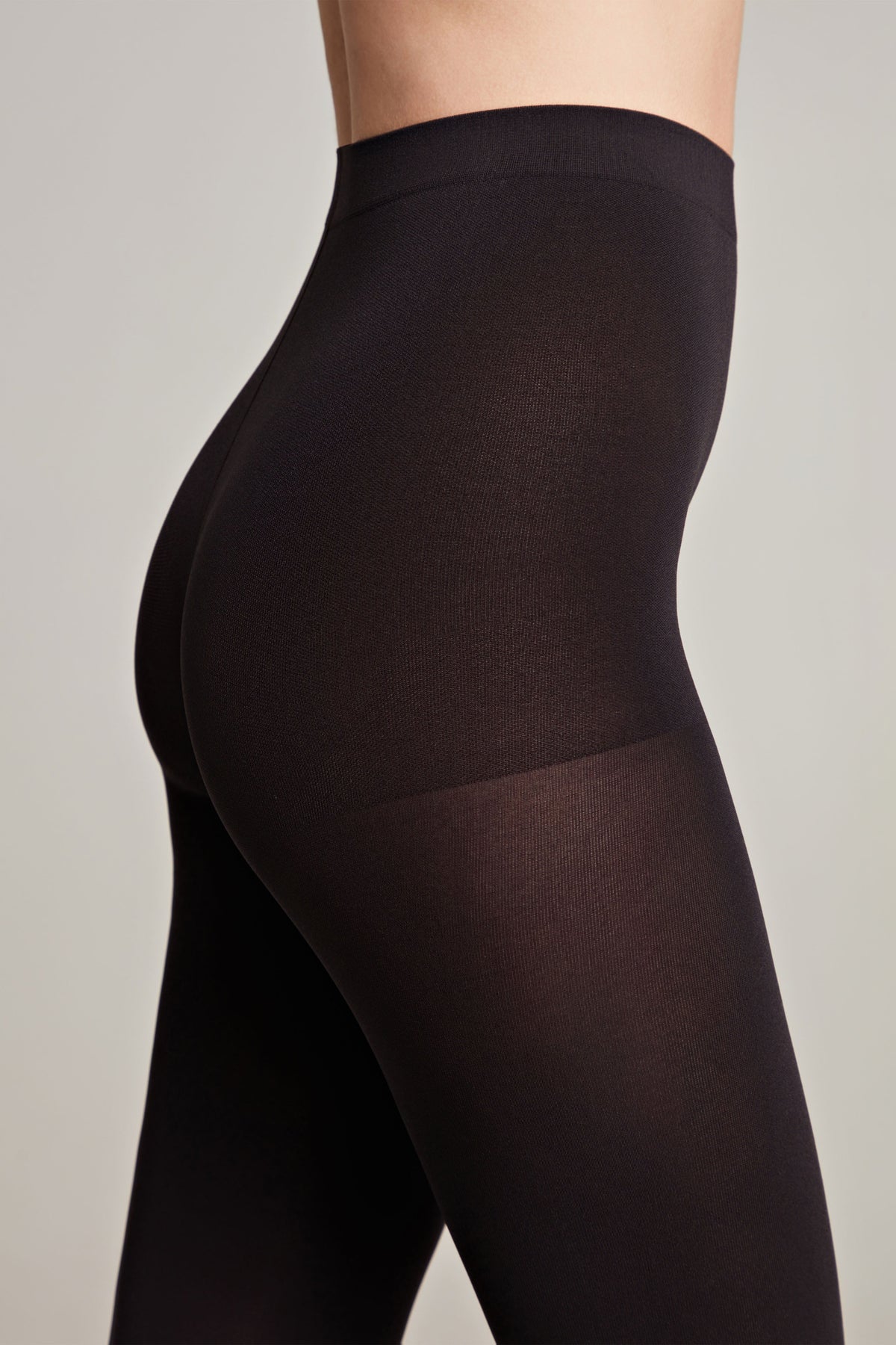Matte dark velour tights close-up on thigh and leg with smooth stretch fabric