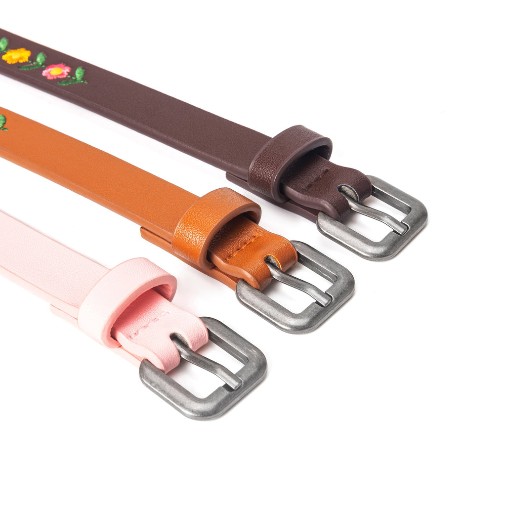 Kids leather belts close-up: three colors with embroidered flowers and metal buckles