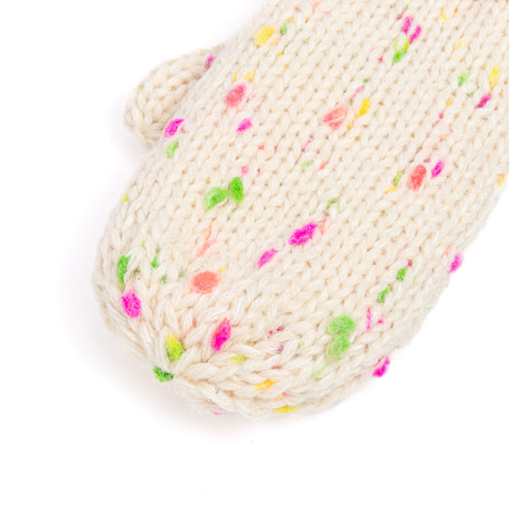 Off-white speckled knit mitten close-up with ribbed cuff and bright multicolor dots