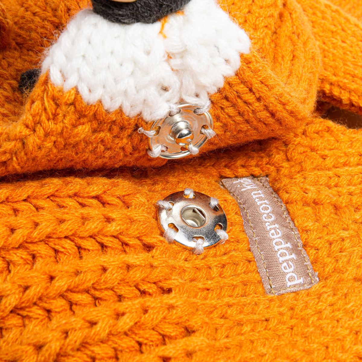 Knitted orange fox scarf with metal clasp and Peppercorn Knits brand tag