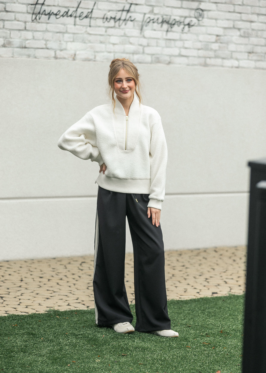 Black wide-leg track pants with white side stripes and drawstring waist, wide leg