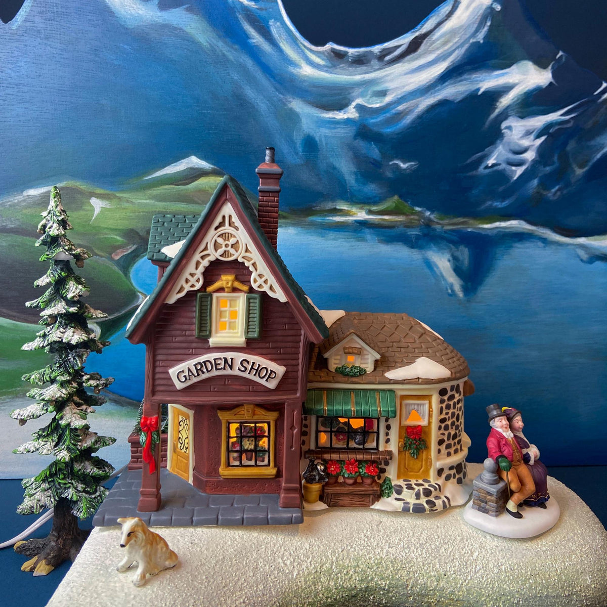 Illuminated porcelain garden shop house with snow caps, front display, and miniature figurines