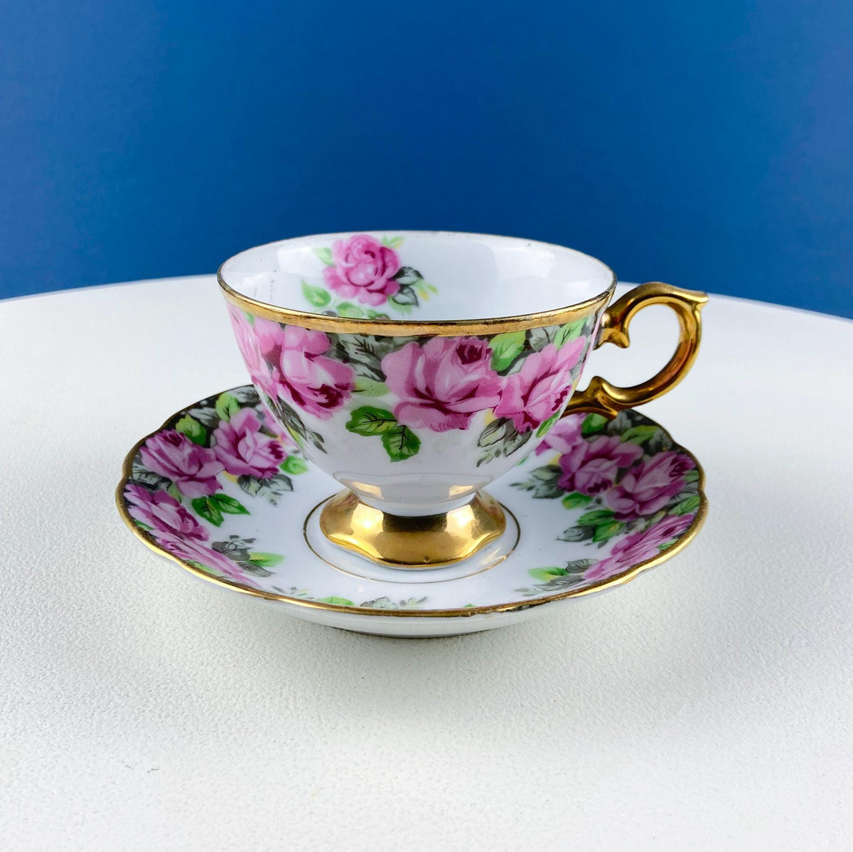 Vintage tea cup and saucer set with gold handle and pink rose floral design