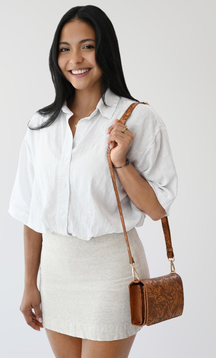 Rust RFID crossbody wallet on model with adjustable strap and zip top