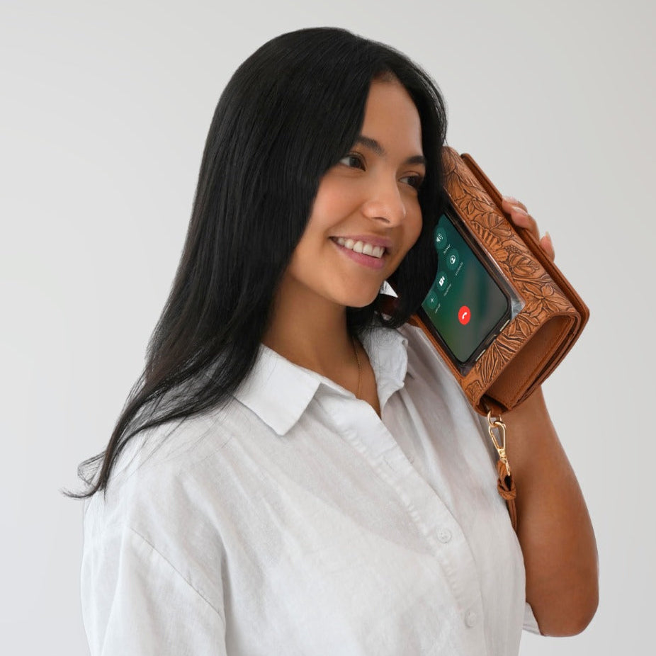 Rust RFID crossbody wallet with phone in clear window, shown close-up